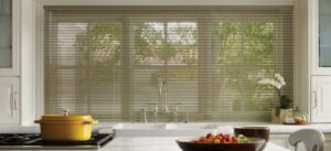 Aluminum mini blinds on the window above the kitchen sink.