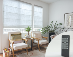 Roman shades on living room windows with remote control motorization features.