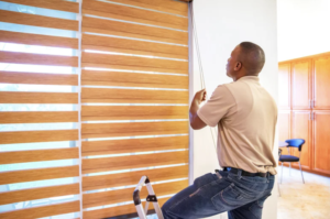 Window Treatment Installer testing out new banded shades on large window.