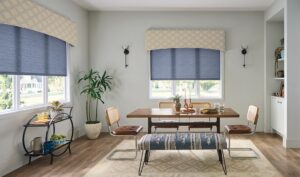 Blue roller shades on dining room windows with yellow patterned valances.