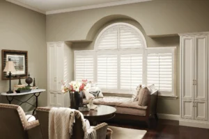 Plantation shutters on living room window with arch.